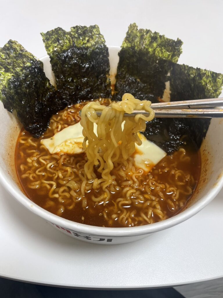 箸で麺を持ち上げた、韓国のりとチーズのせのラーメン